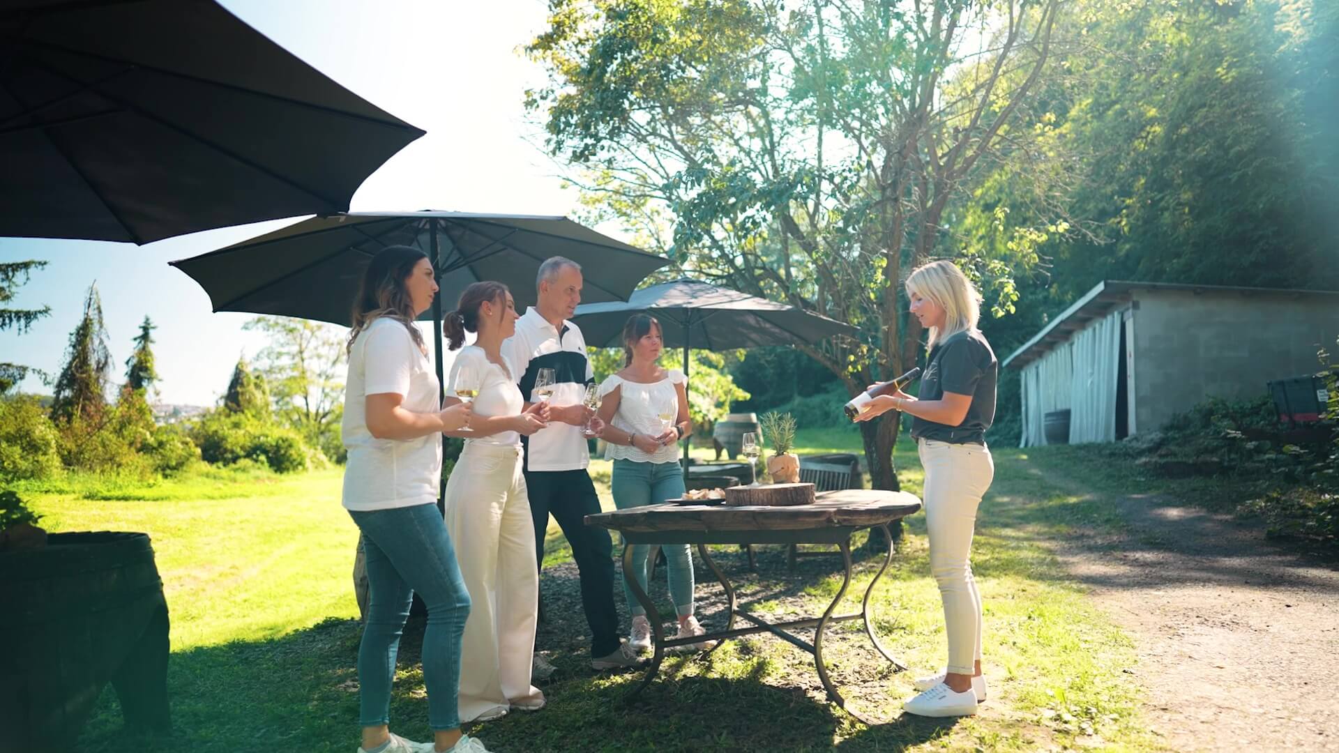 Tourguide erklärt Wein an vier Gäste an der Weinhütte in der Marienbergtour im Koblenzer Marineberg im Weingut Schwaab. 