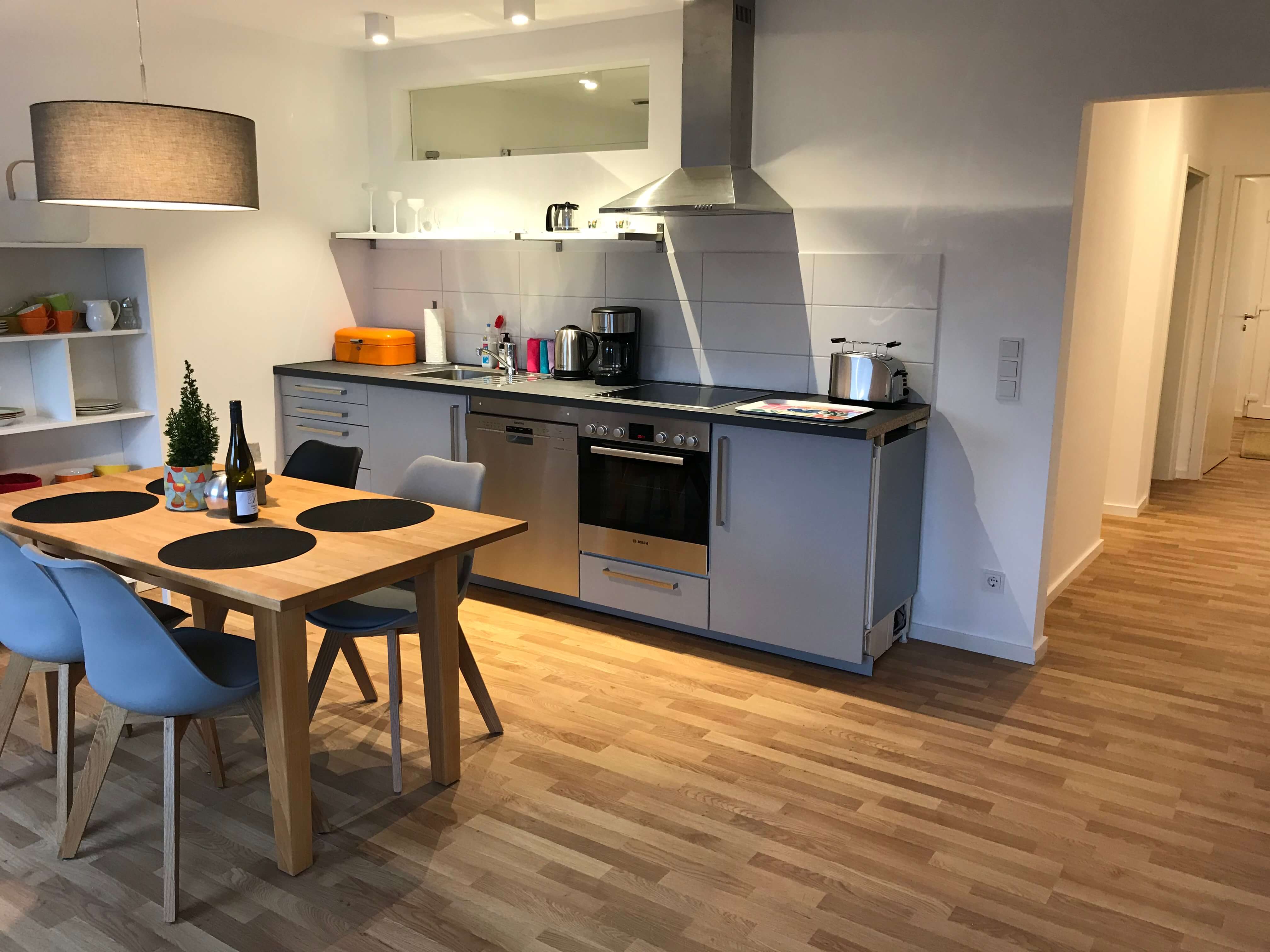 Blick in die Küche mit Küchenzeile, Tisch und Stühlen im Business Apartment vom Weingut Schwaab Wohnen auf Zeit