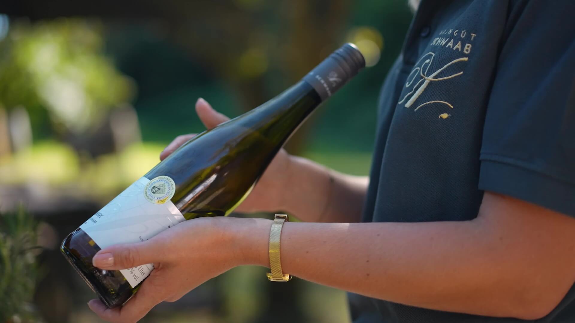 Tourguide hält Weinflasche in der Hand und erklärt den Wein für die Gäste der Marienbergtour. 