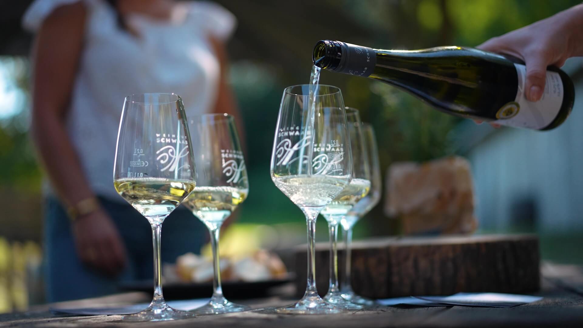 Tourguide schenkt Wein in Weingläser ein während der Marienbergtour im Weingut Schwaab. 