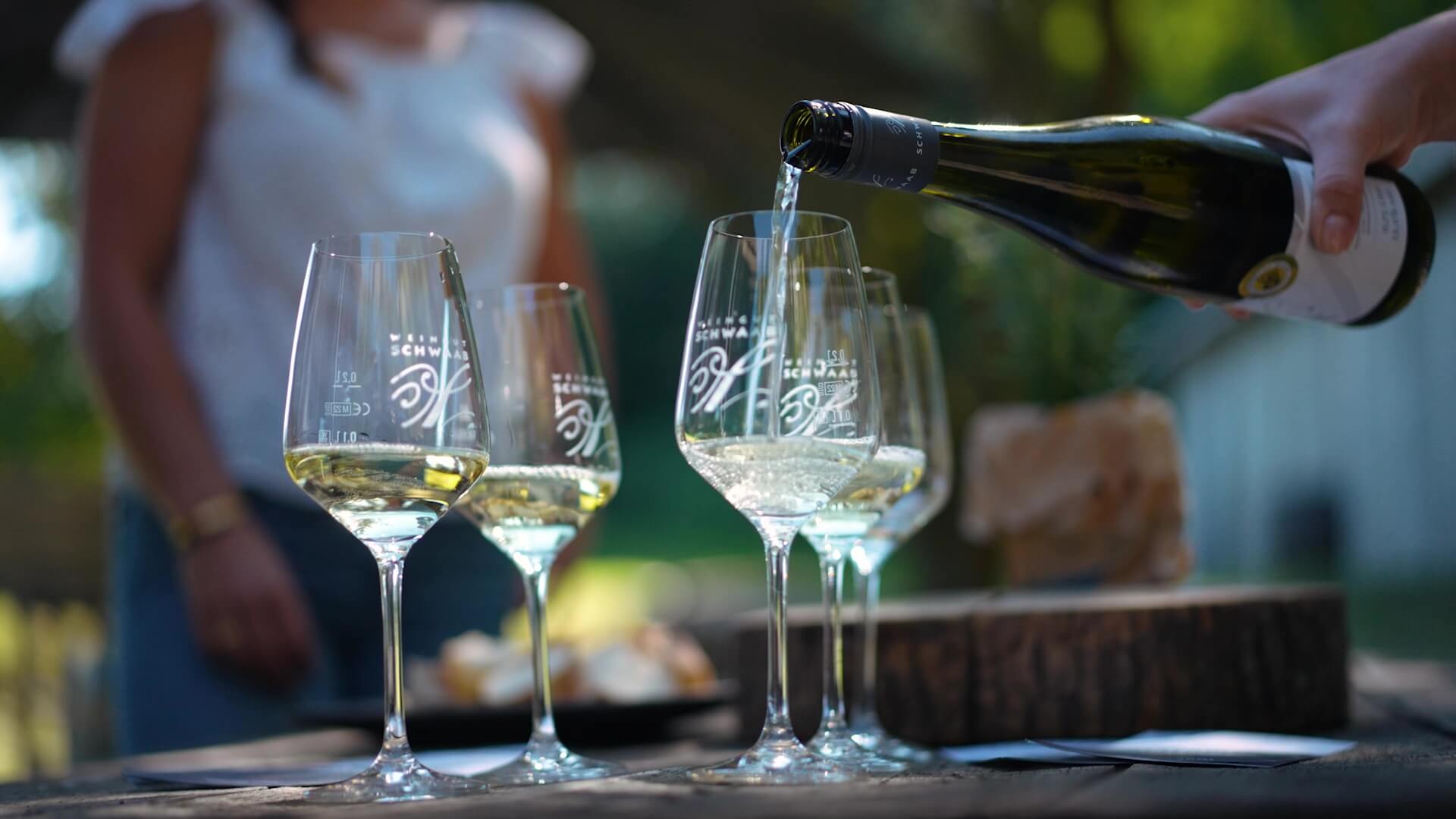 Weinverkostung im Weingut Schwaab. Tourguide schenkt Wein in Weingläser ein während der Marienbergtour im Weingut Schwaab.